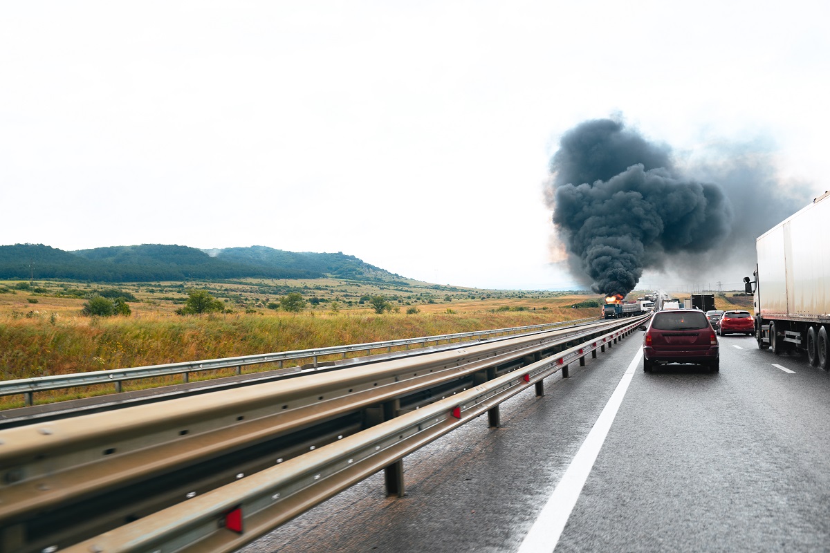 Truck Accident with smoke billowing above it.