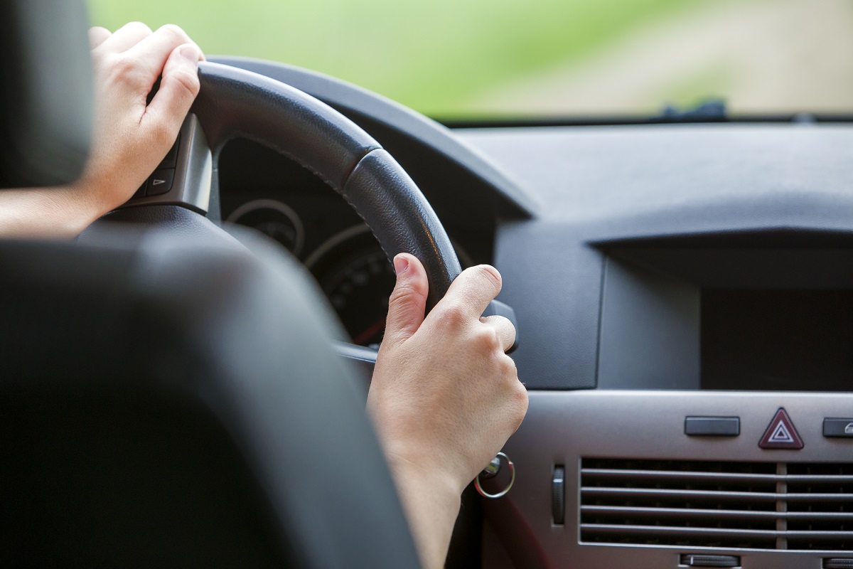 A driver's hands on the steering wheel.