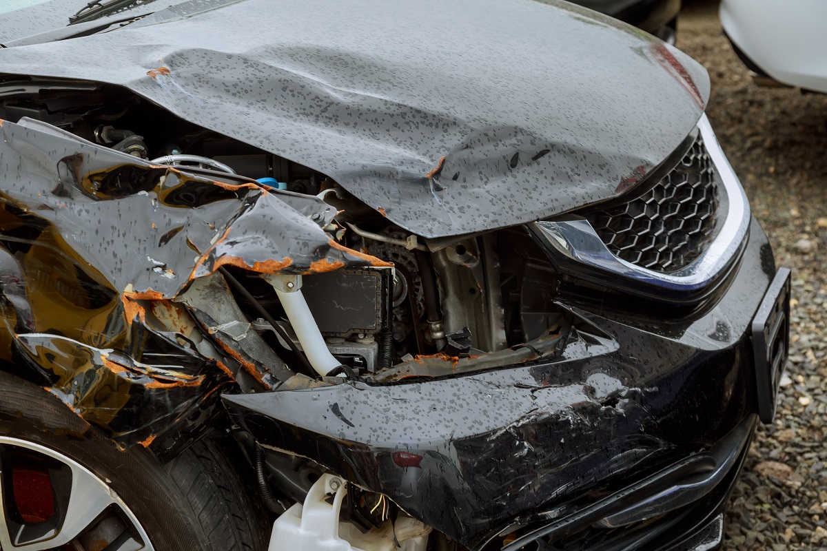 The damaged hood and front end of a black car.