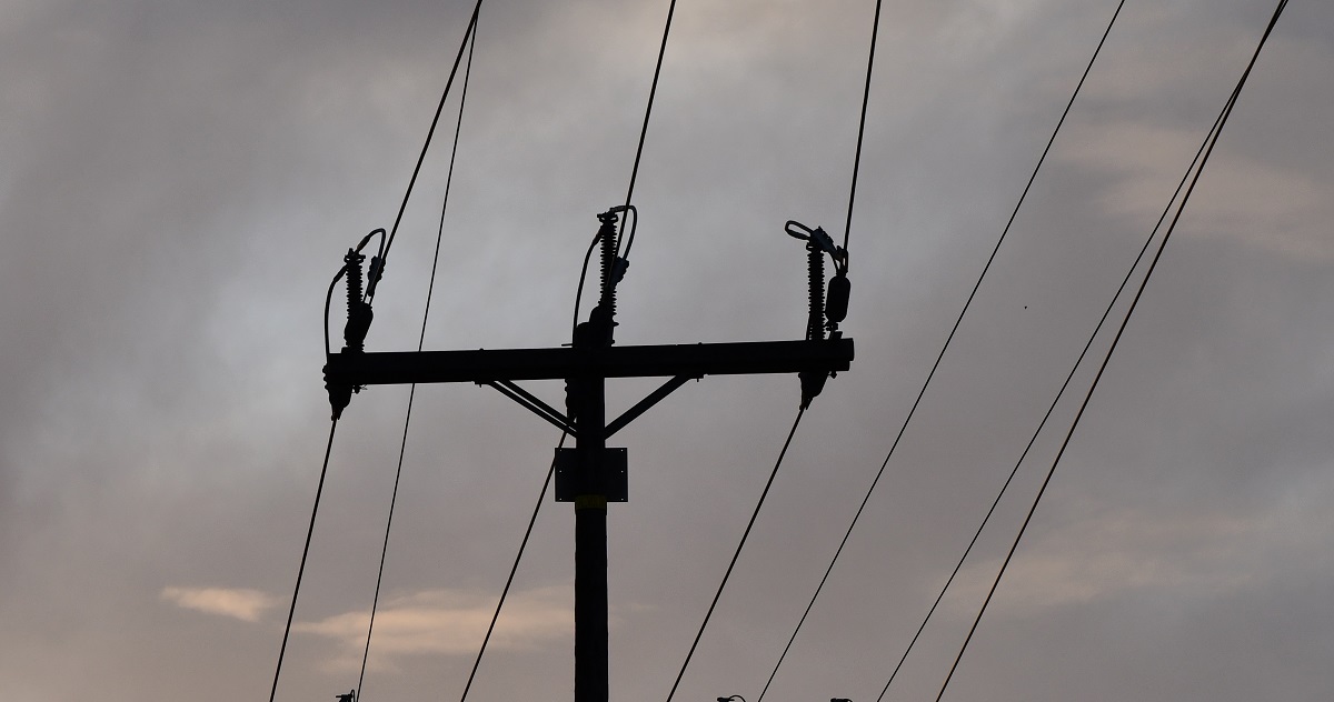 The top of a wooden utility pole on a hazy day