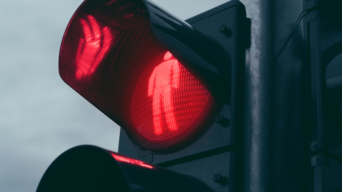 A red walk sign on a traffic light.