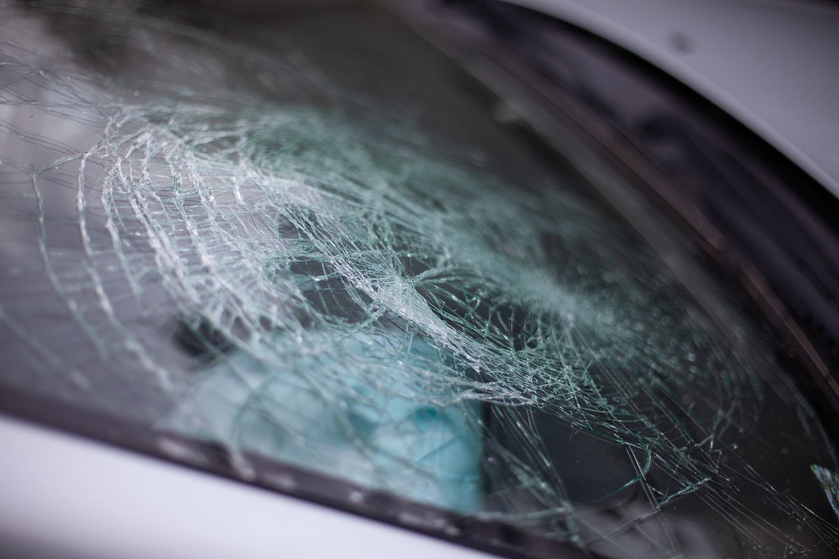 A close-up of a broken windshield following a crash.