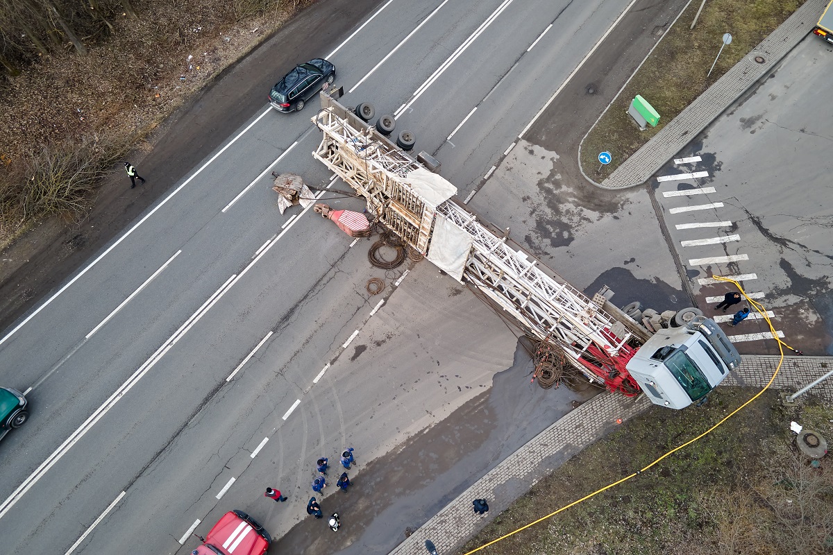 A semi-truck lying on its side across a road after a crash.