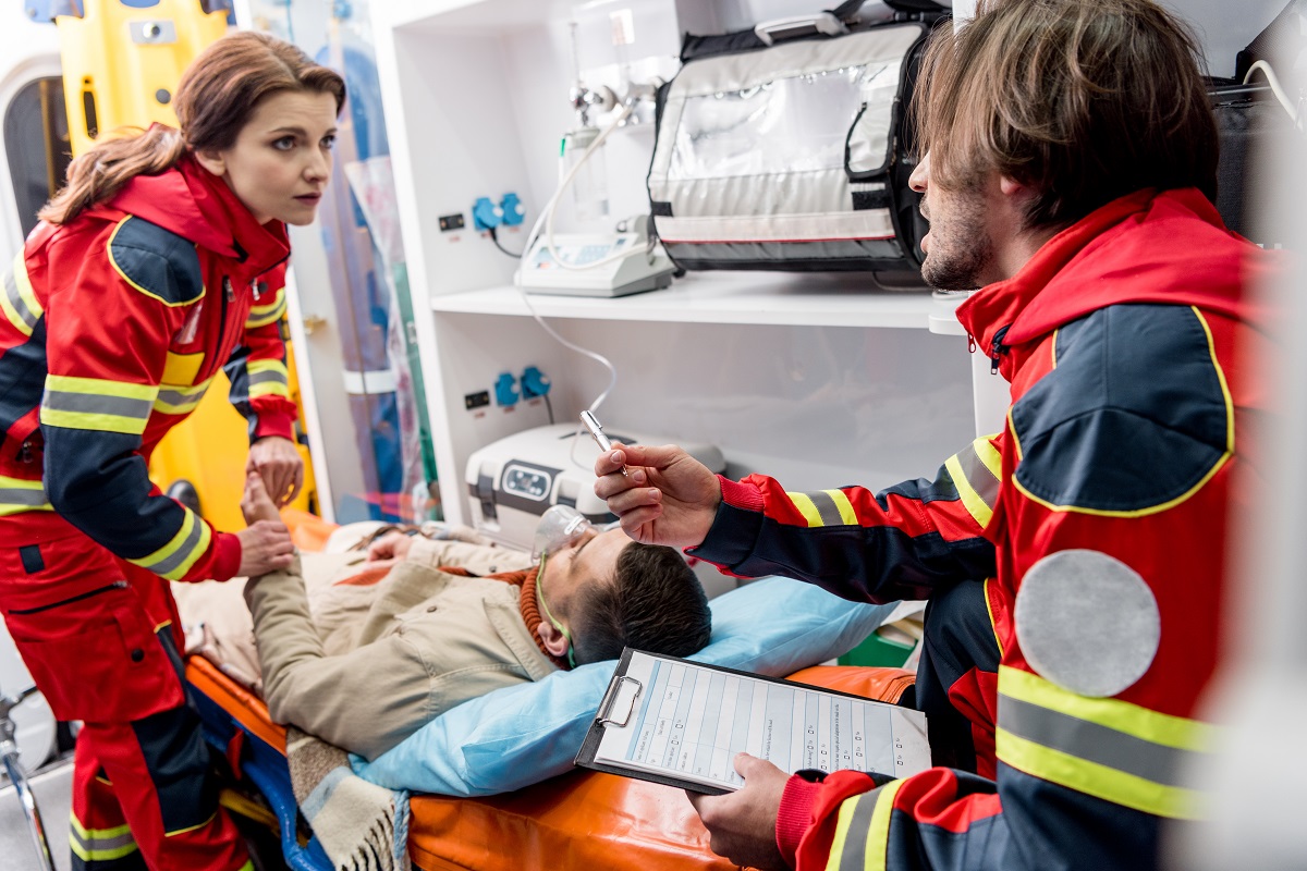 EMSs putting an injured man in an ambulance